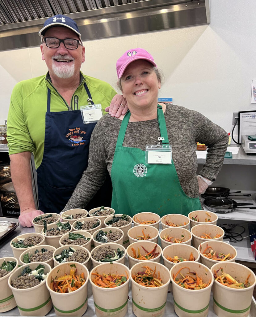 people standing smiling food preparation